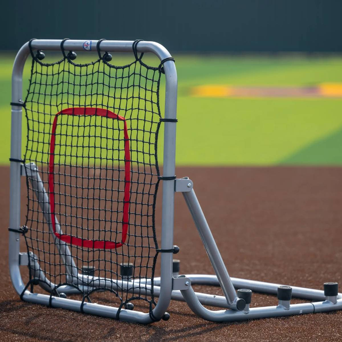 Large rebounder with silver frame and red target on field front angle setup for grounders