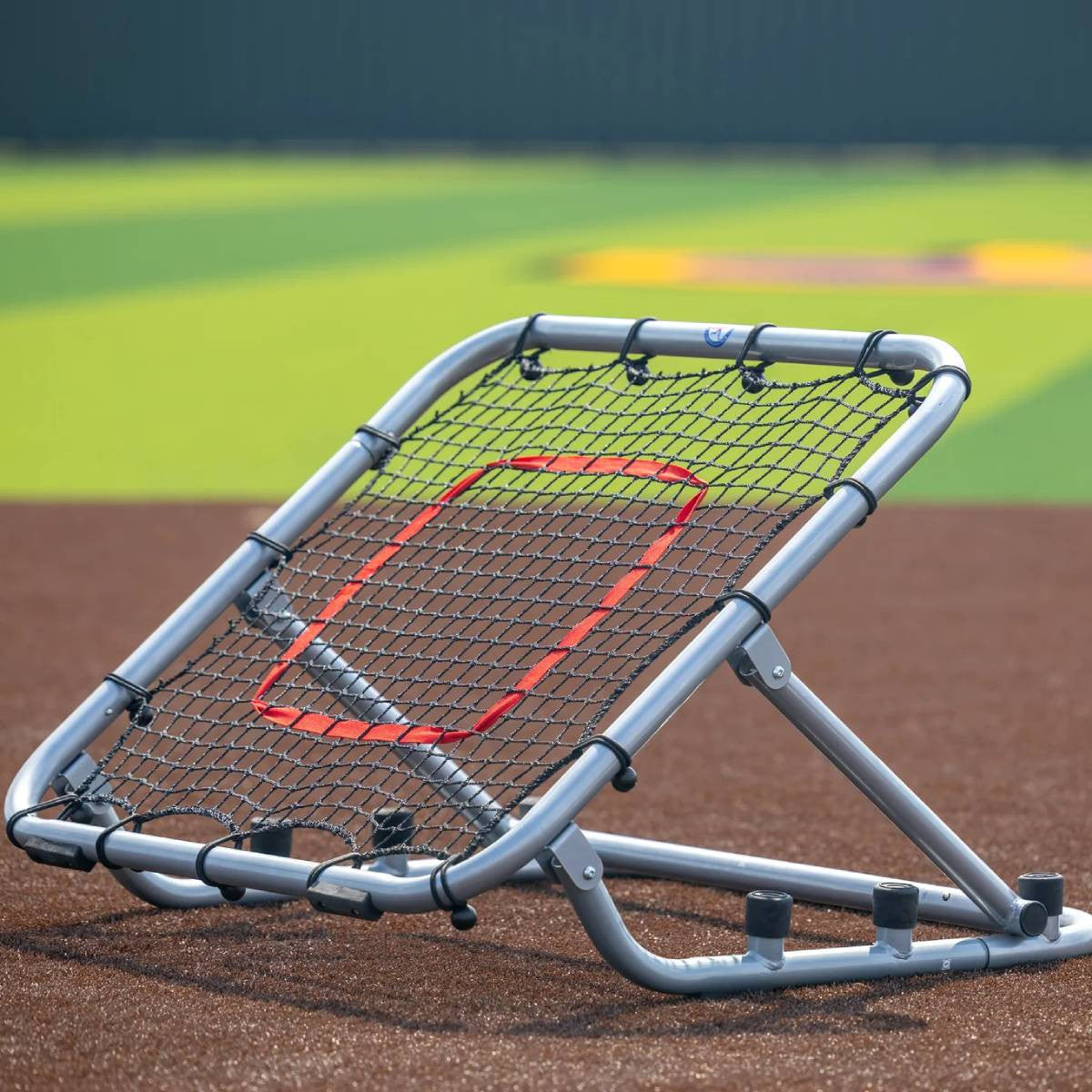 Large rebounder with silver frame and red target on field front angle setup for fly balls